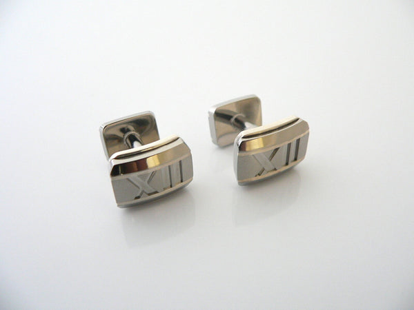 A pair of silver and titanium cufflinks with Roman numerals engraved on the bar.