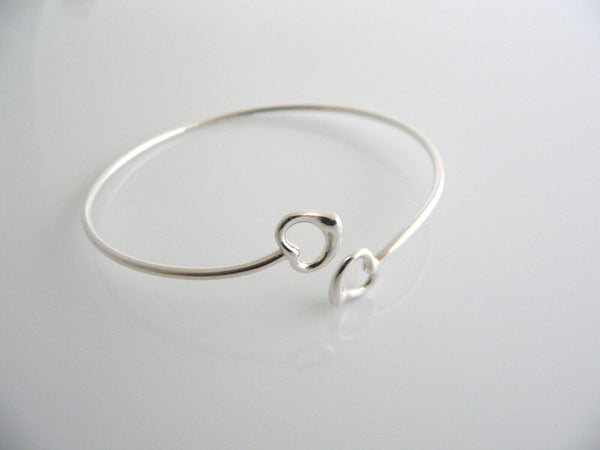 A sterling silver Tiffany & Co. Elsa Peretti double open heart bangle bracelet on a white background.