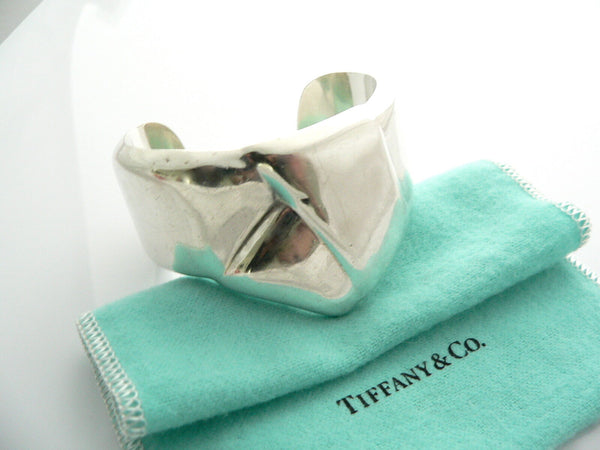 A Tiffany & Co sterling silver Peretti knot ribbon bow cuff bracelet, displayed on a blue Tiffany & Co. gift pouch.