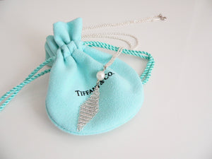 Silver necklace with a pearl pendant on a Tiffany & Co. branded blue drawstring bag.