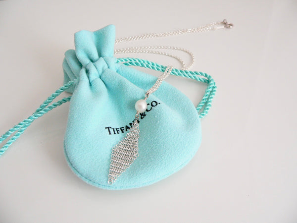 Silver necklace with a pearl pendant on a Tiffany & Co. branded blue drawstring bag.