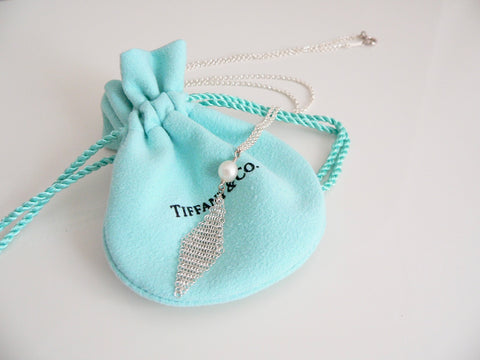 Silver necklace with a pearl pendant on a Tiffany & Co. branded blue drawstring bag.