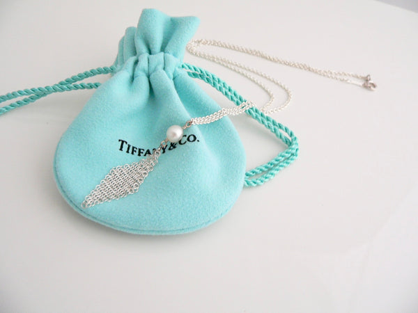 Silver necklace with a pearl pendant on a Tiffany & Co. jewelry pouch.